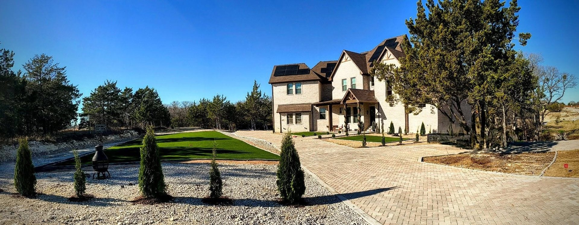 Two-story brick home with paver driveway and landscaped grounds, built by Cincero Homes